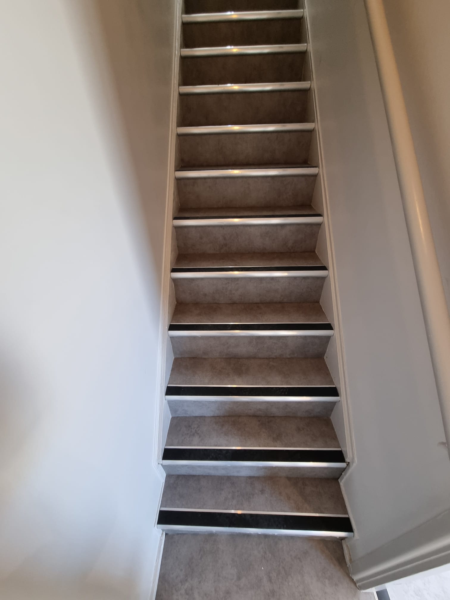 Vinyl flooring up stairs with a black slip rated nosing