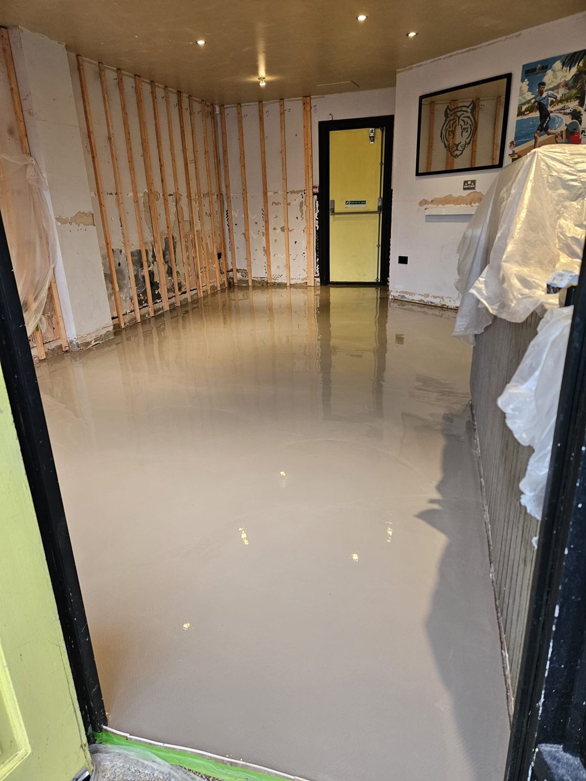 Freshly poured flexible levelling screed across the café floor