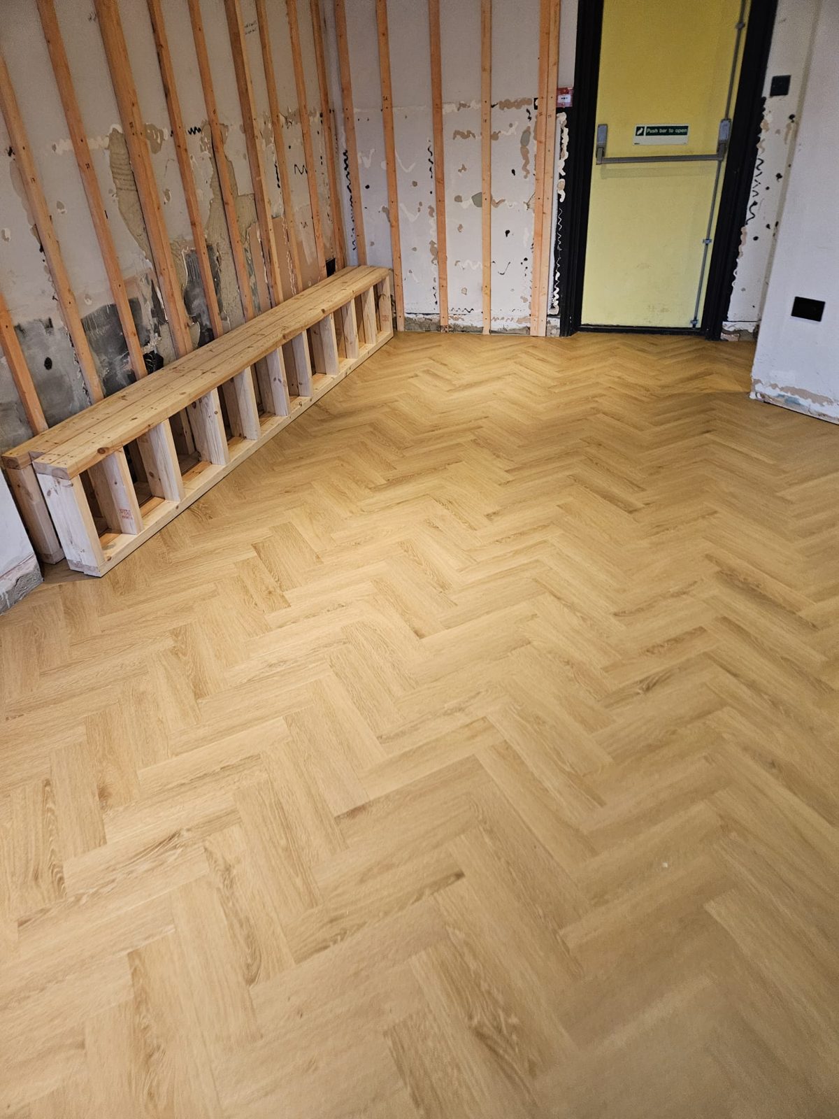 Close view of herringbone LVT laid alongside new bench seating
