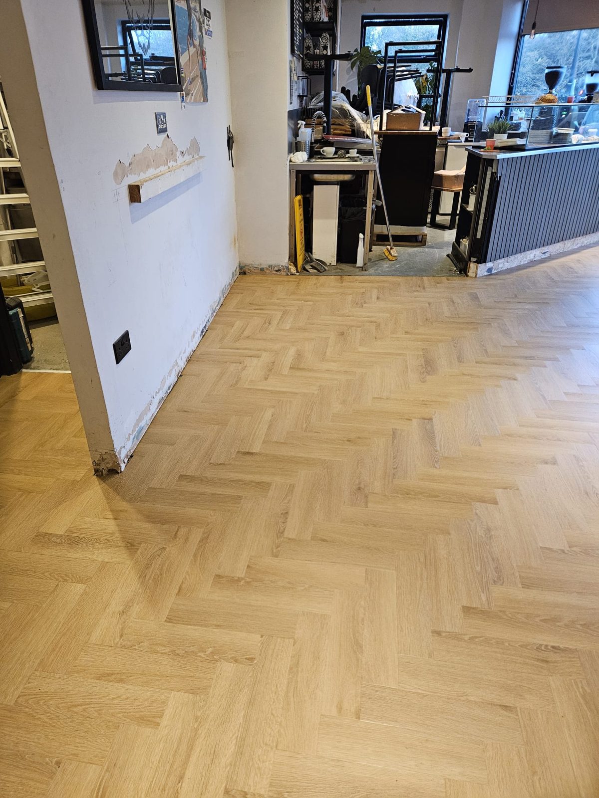 Herringbone LVT flowing around the café counter and into the back room